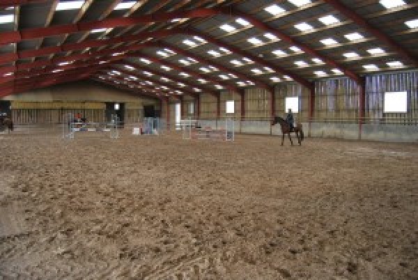 Un manège spacieux (40 x 60) avec sol fibré et entretenu chaque semaine- parc d'obstacle avec soubassements pour entraîner votre cheval